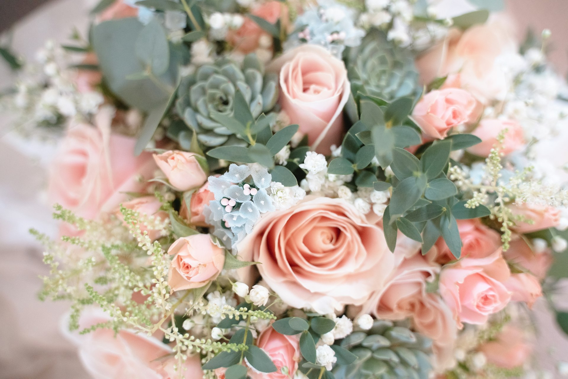 a bridal bouquet of pink roses and succulents